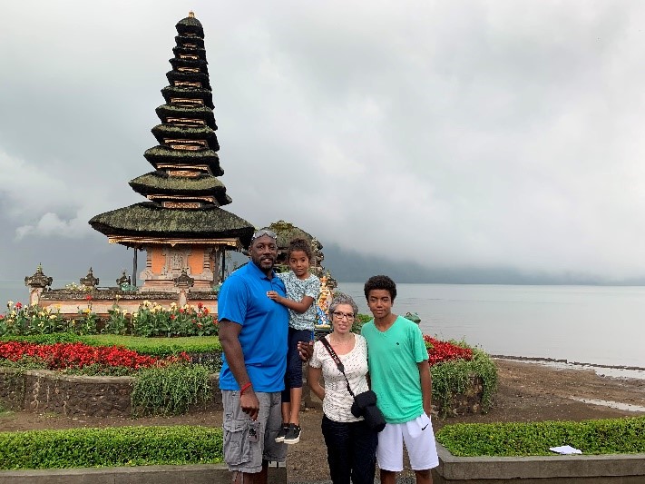 Glen Elliot posing with his family in front of a temple in Bali. 