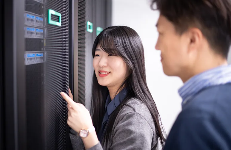 Asian male and Asian female engineer inspecting a server