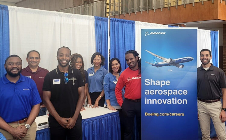 Group photo of students at Boeing booth.