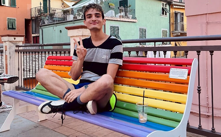 Gus sitting on rainbow bench
