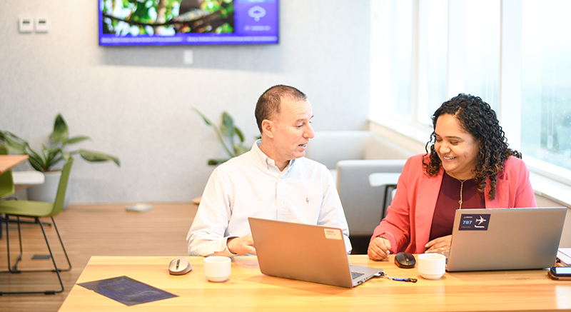 two workers on laptops