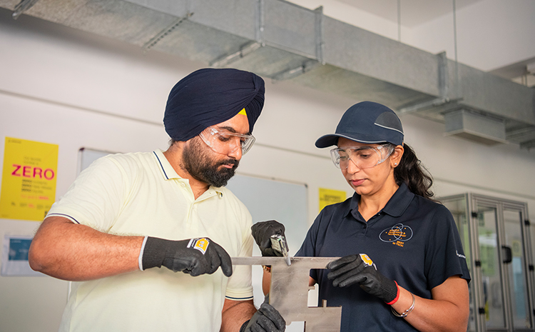 Indian male and Indian female employee looking at a computer screen in an office cubicle