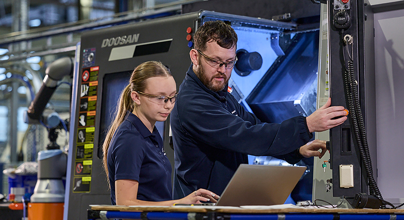 young male apprentice inspecting an aircraft engine