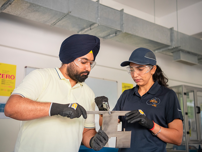 Indian male and Indian female employee inspecting an electronic device together