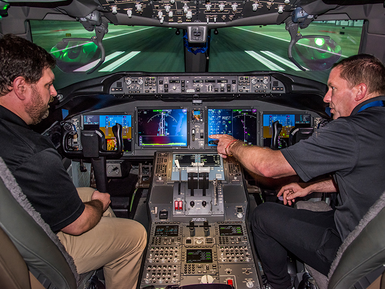 Two male employees in a cockpit