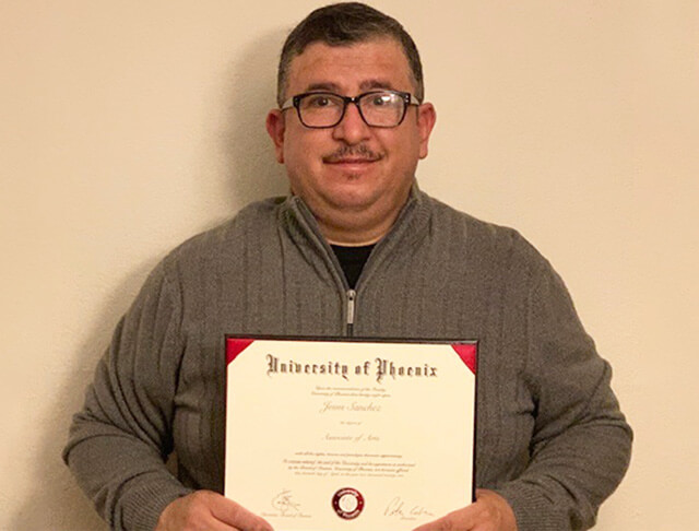 Jesus Sanchez holding up a certificate