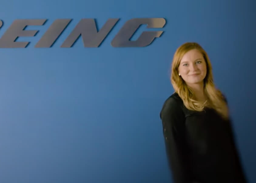 Emily in front of Boeing logo.