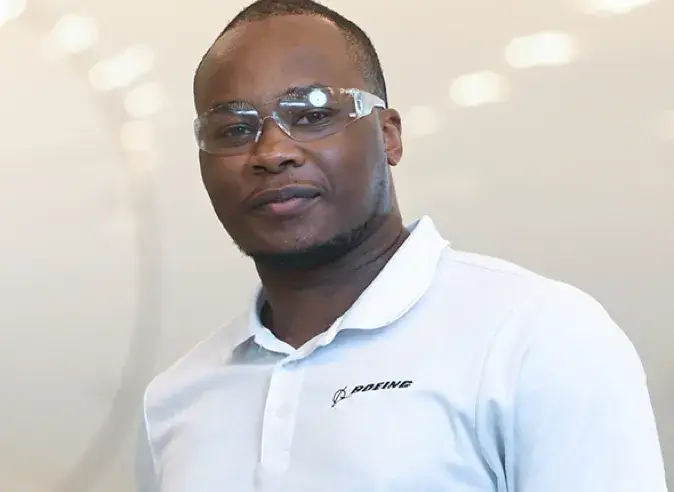 black male employee wearing a Boeing polo shirt and safety goggles