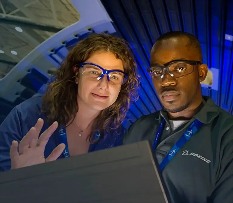 male and female engineer wearing safety goggles and working on an aerospace project