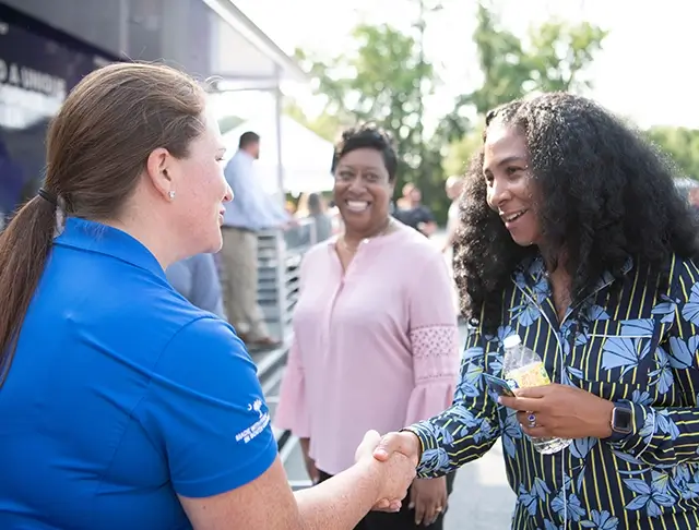Boeing employee greeting a prospective employee at an outdoor hiring event