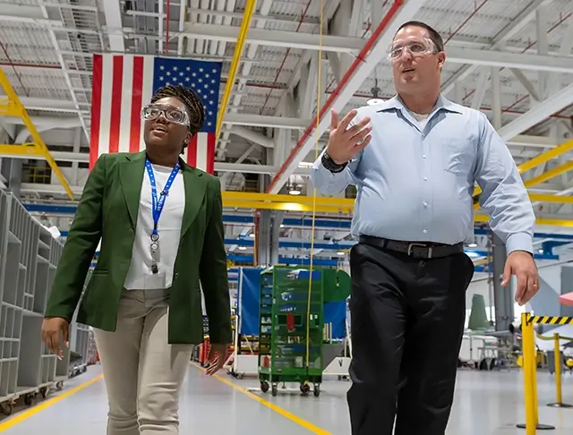 2 employees touring a Boeing manufacturing facility