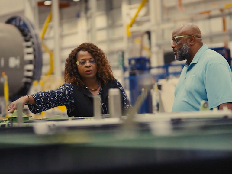2 employees touring a Boeing manufacturing facility