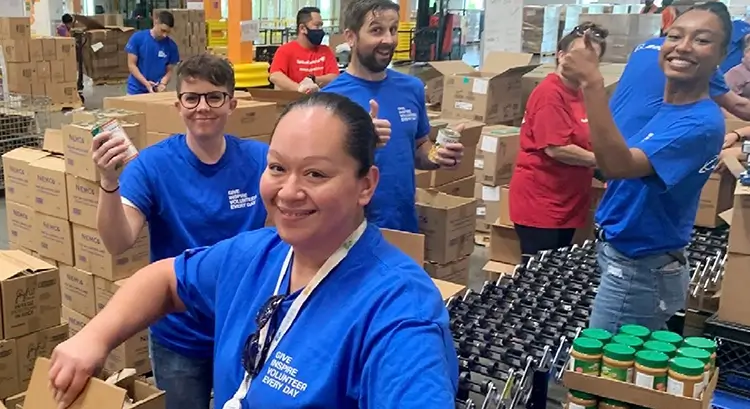 several employees smiling for a photo at a charity food drive