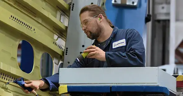 Male employee working on the outer shell of an airliner