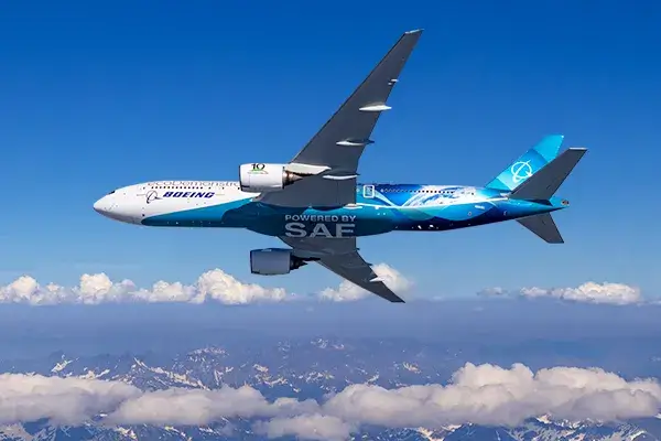 Boeing airliner flying above clouds and mountains