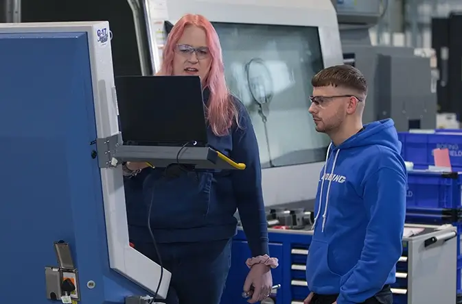 a female and male employee looking at a computer screen