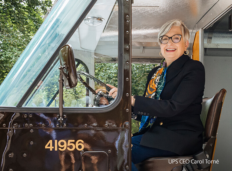 UPS CEO Carol Tome is smiling while sitting in a delivery truck