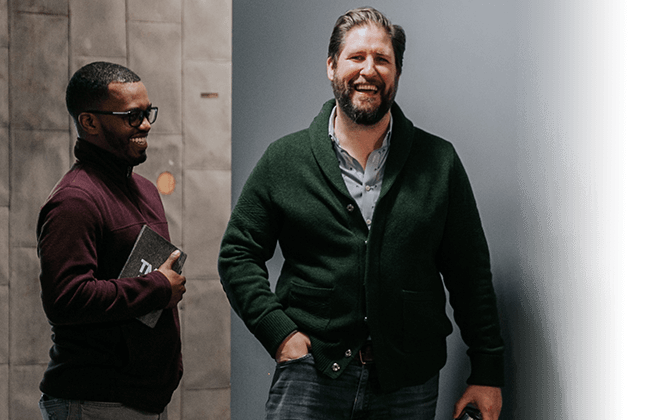 Two people laughing while waiting on an elevator