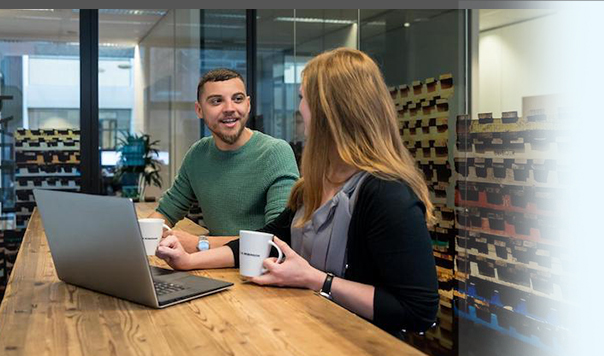 Two coworkers talking over coffee