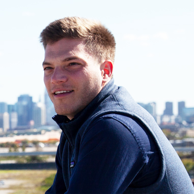 Profile picture of young man with a city skyline in the background