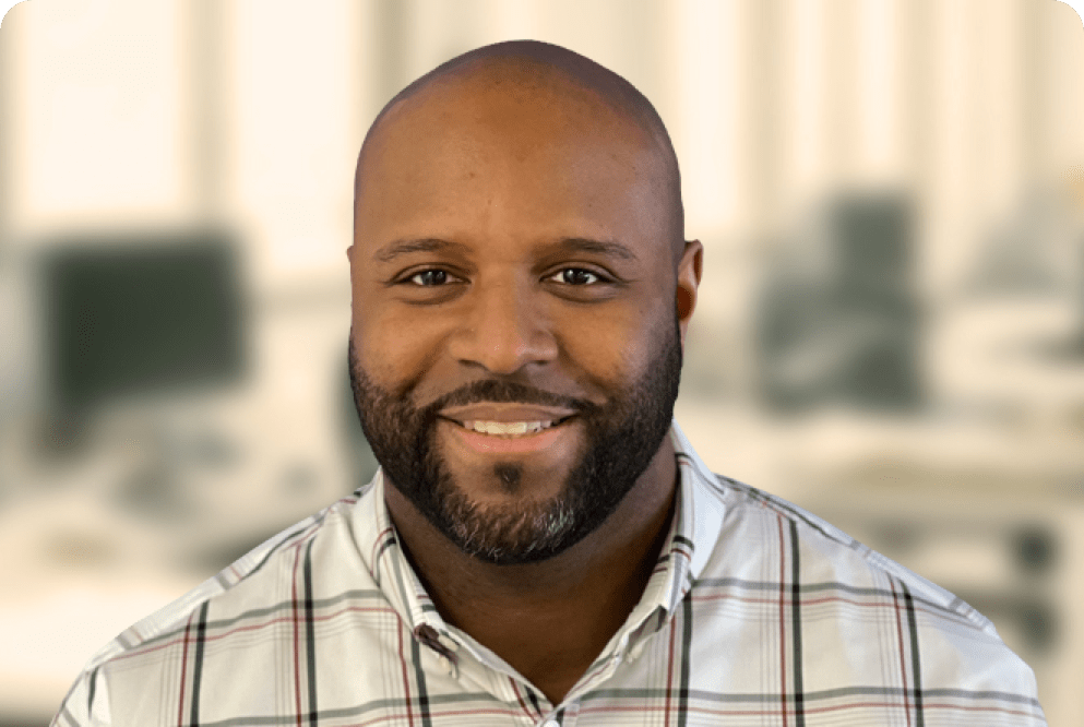 Headshot of man smiling in plaid shirt