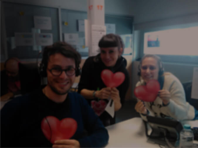 Three employees holding hearts