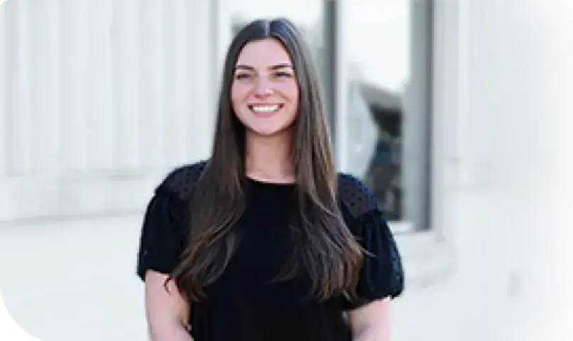 Woman employee outside a office building smiling for a picture