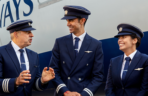 Meet our Pilot Recruitment team. Three BA pilots in uniform talking together.