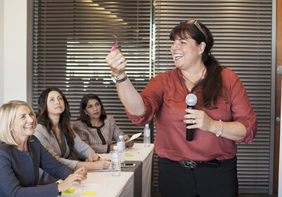 Woman with micrphone at front of classroom teaching