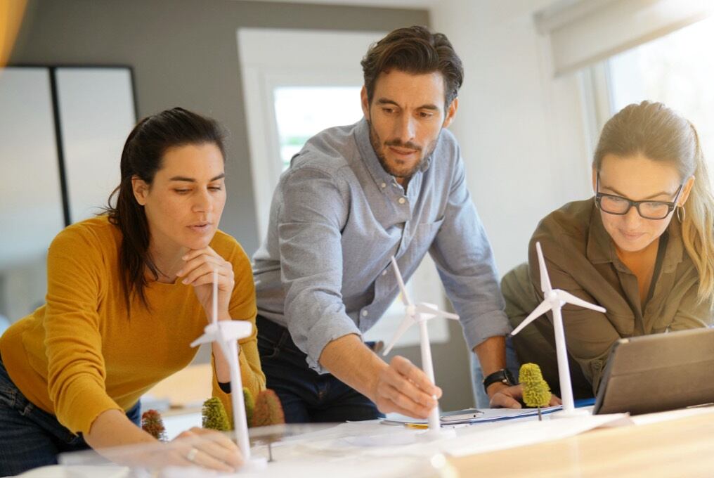 A man and 2 women looking at a landscape design