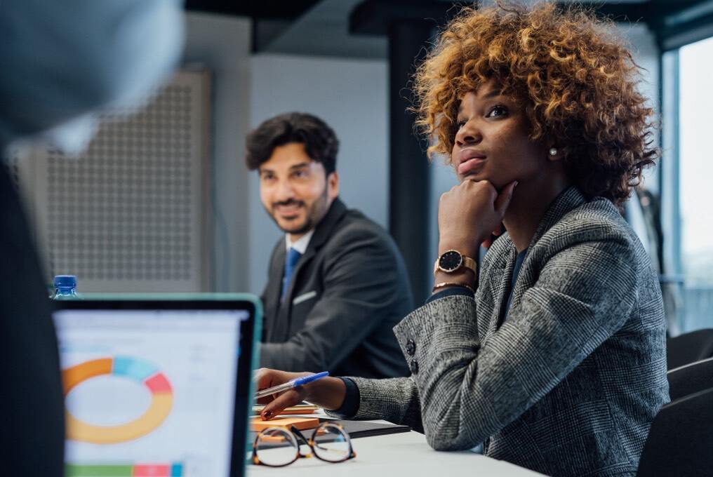 three people sitting in a meeting