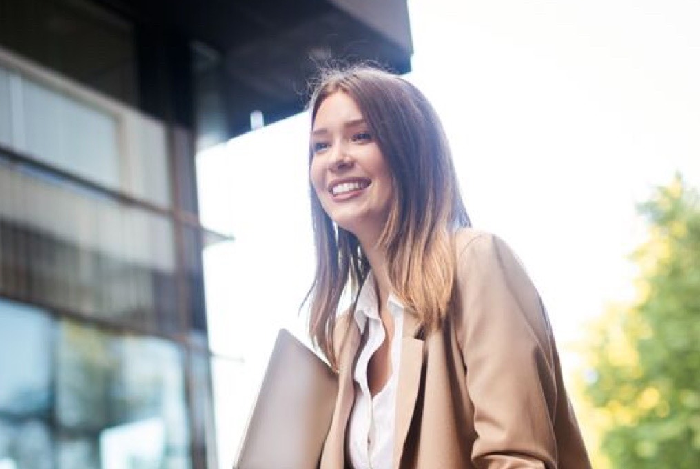 Uma mulher de terno executivo com um sorriso.