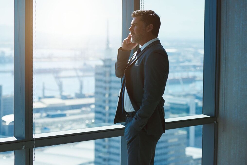 Homme d'affaires au téléphone dans un bureau en hauteur.