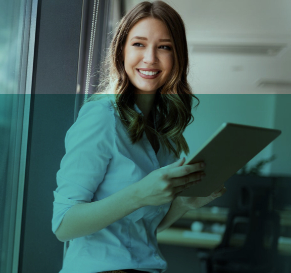 A professional woman in an office setting, holding a tablet device.