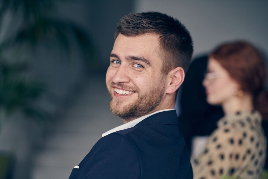 Um homem de terno sorrindo com confiança.