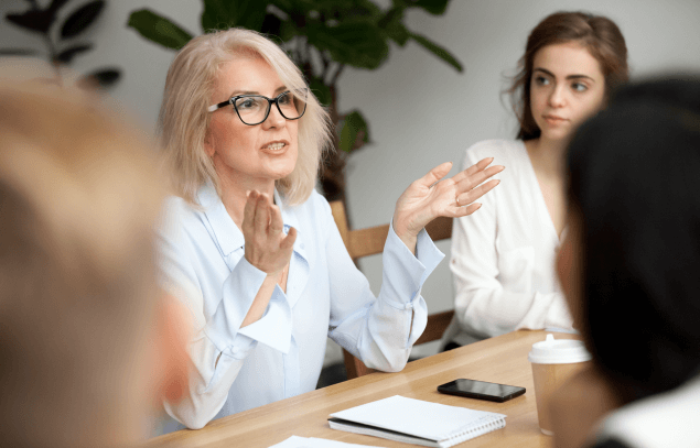 Woman talking on a table with work collegues