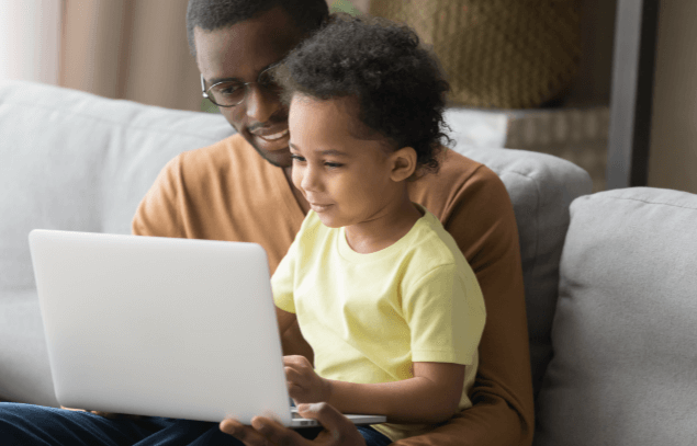 Male staff member working from home holding a child