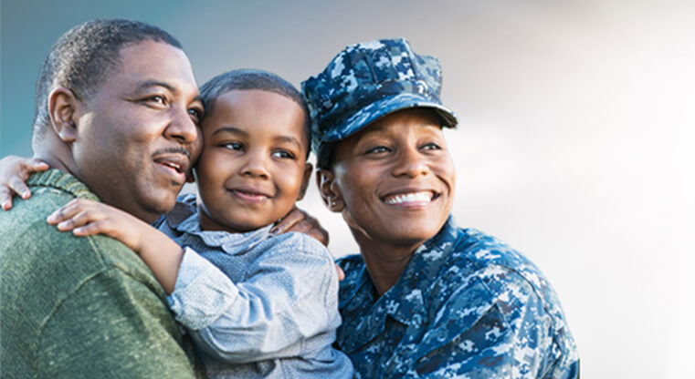 Veteran family, father holding toddler and smiling, mother in her uniform