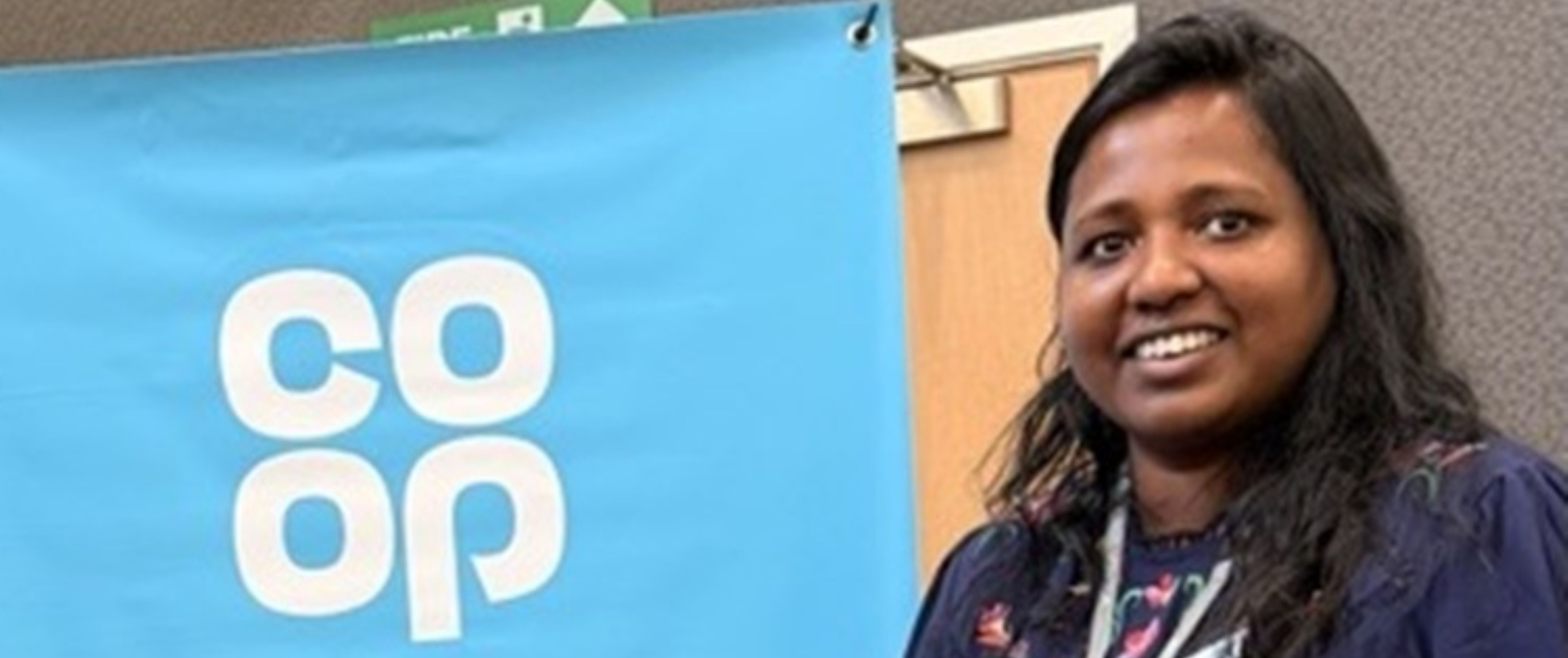 Woman smiling next to a recruiting now banner with the Co-op logo