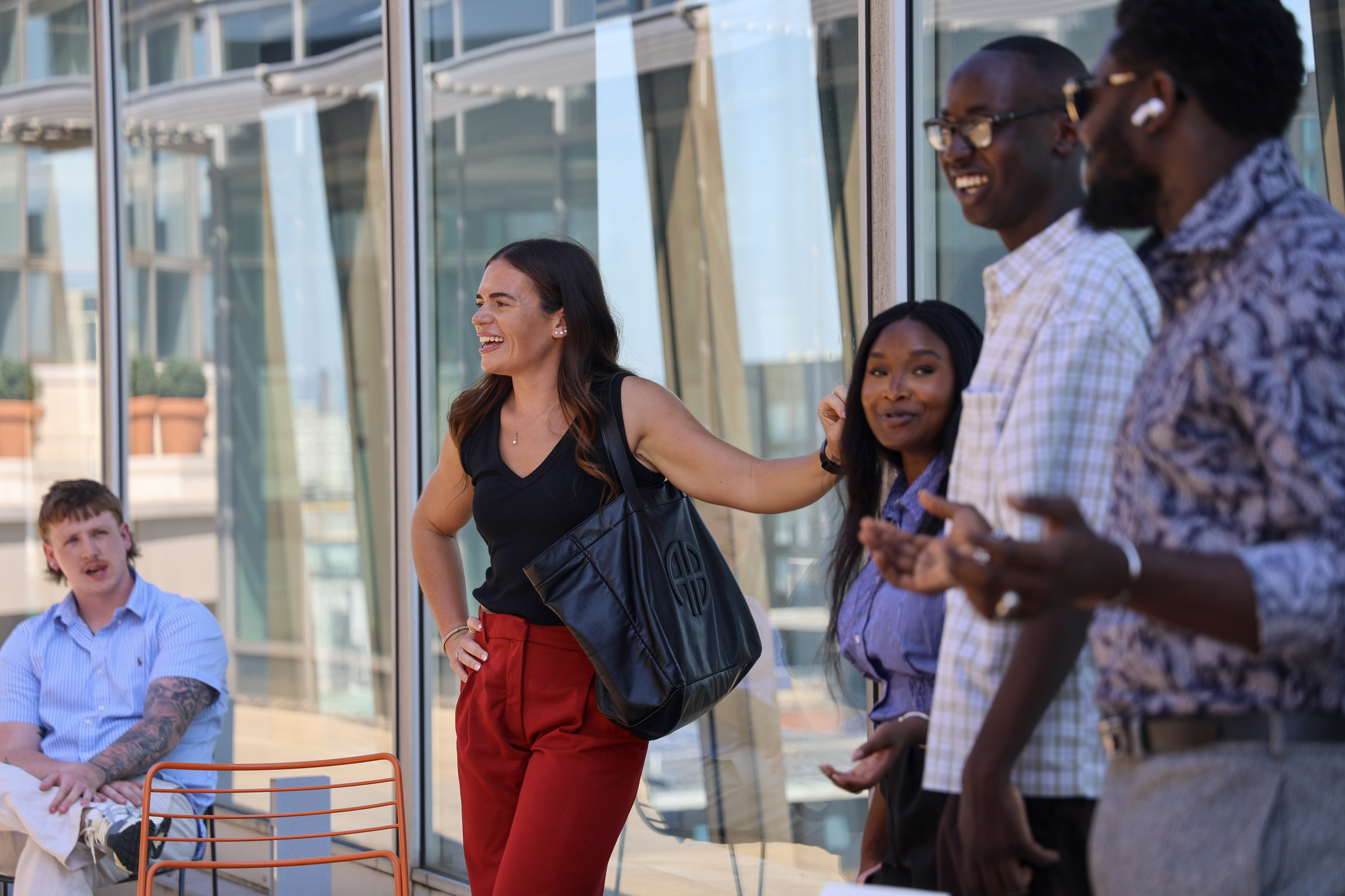 Colleagues interact on a balcony in a modern office setting.