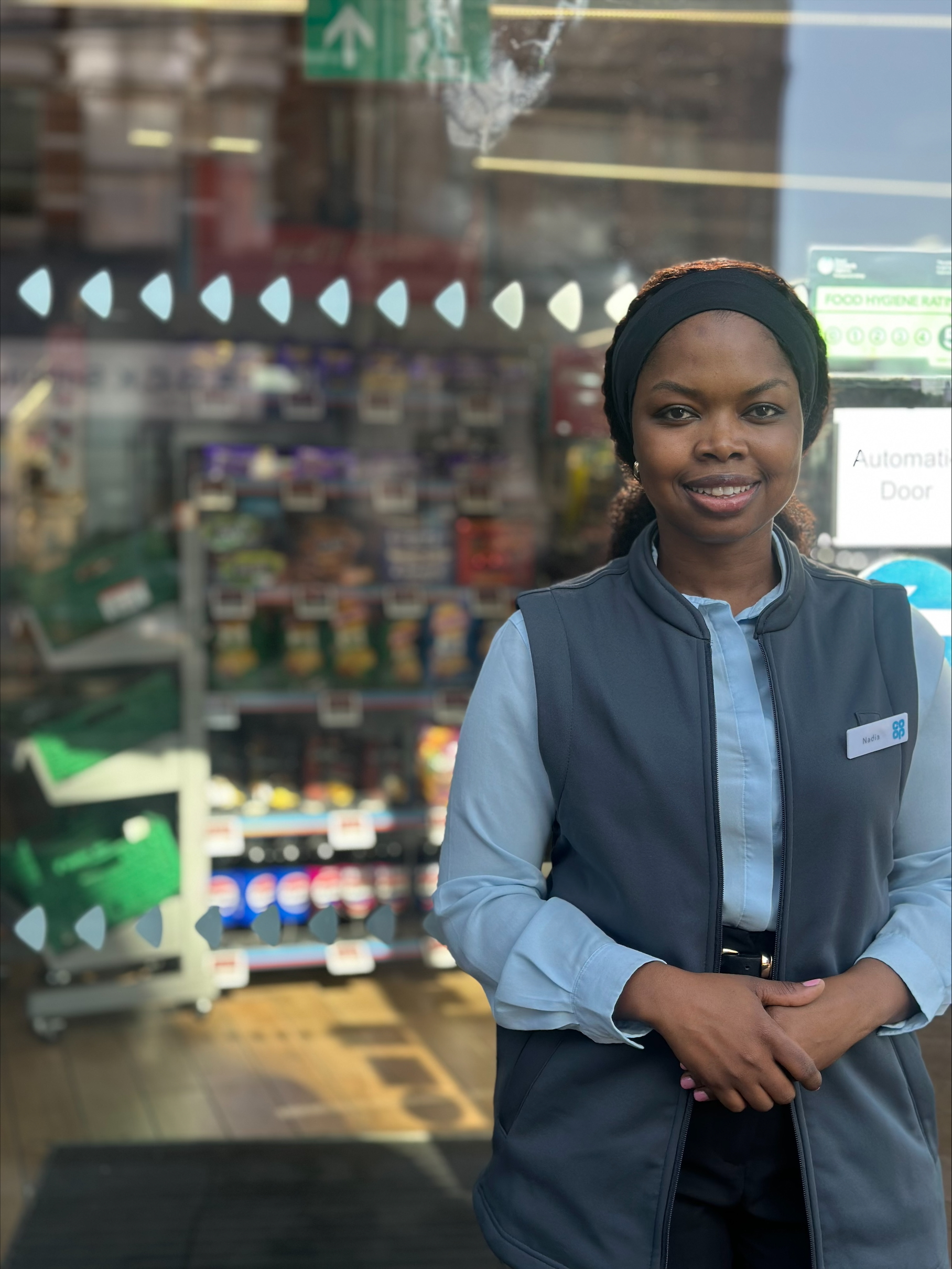 woman smiling outside of a Co-op food store