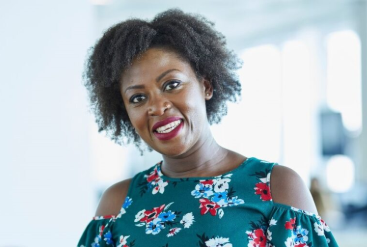 Smiling woman in floral dress with natural curly hair