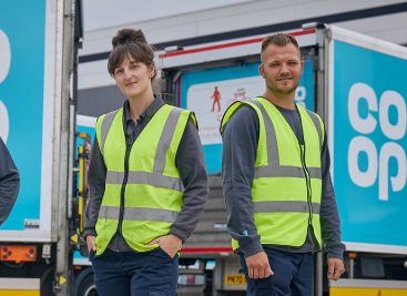 Co-op staff in safety vests near branded delivery vans