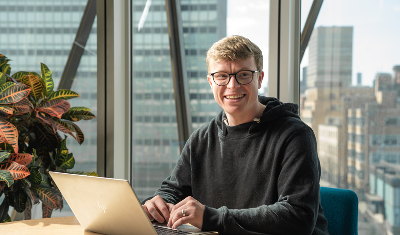 Employee smiling pointing at laptop computer