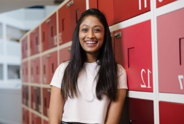 Smiling woman standing near red office lockers