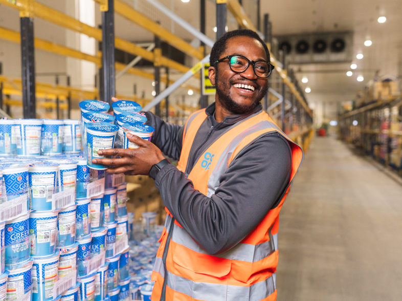 Individual in a high-visibility vest standing in front of a Co-op delivery truck