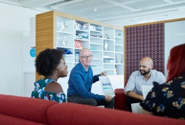 Colleagues having a discussion in a modern office lounge