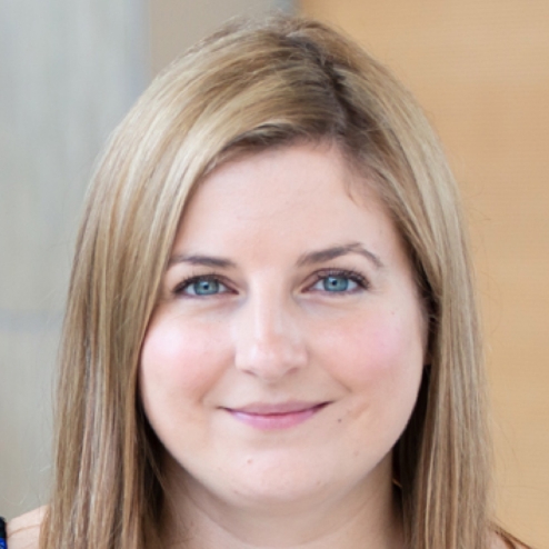 Smiling woman with blonde hair in office setting.