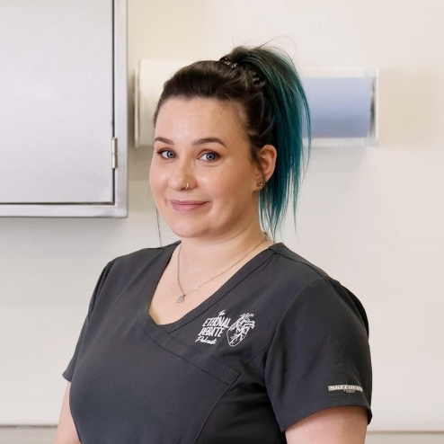 Woman in uniform standing in a clinical workroom.
