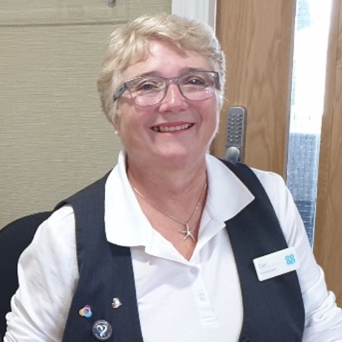 Smiling woman at reception desk in funeral home.